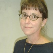 Woman with dark hair and dark-rimmed glasses